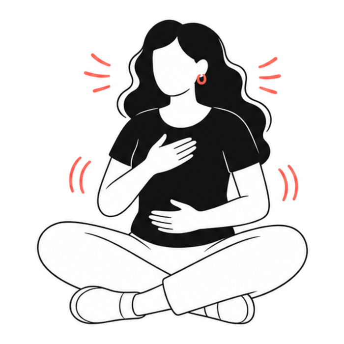 A woman sitting with a hand on her chest, breathing